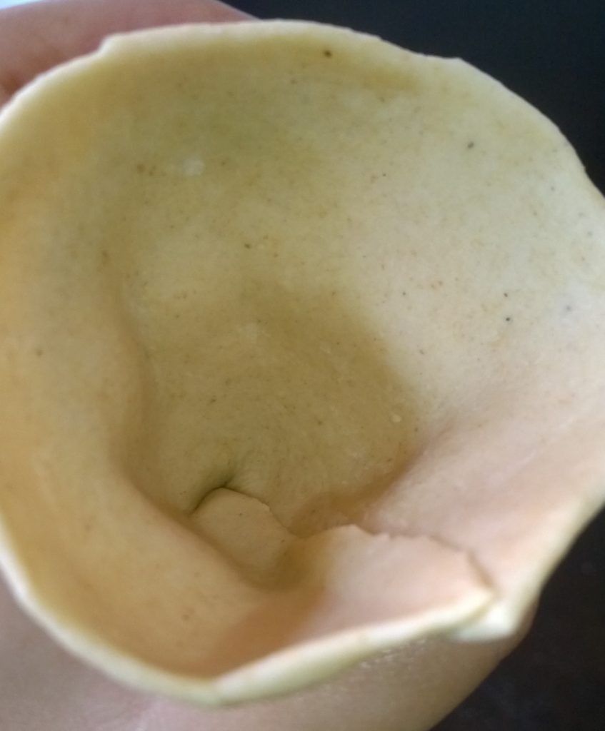 Flattened dough given a form of a cup