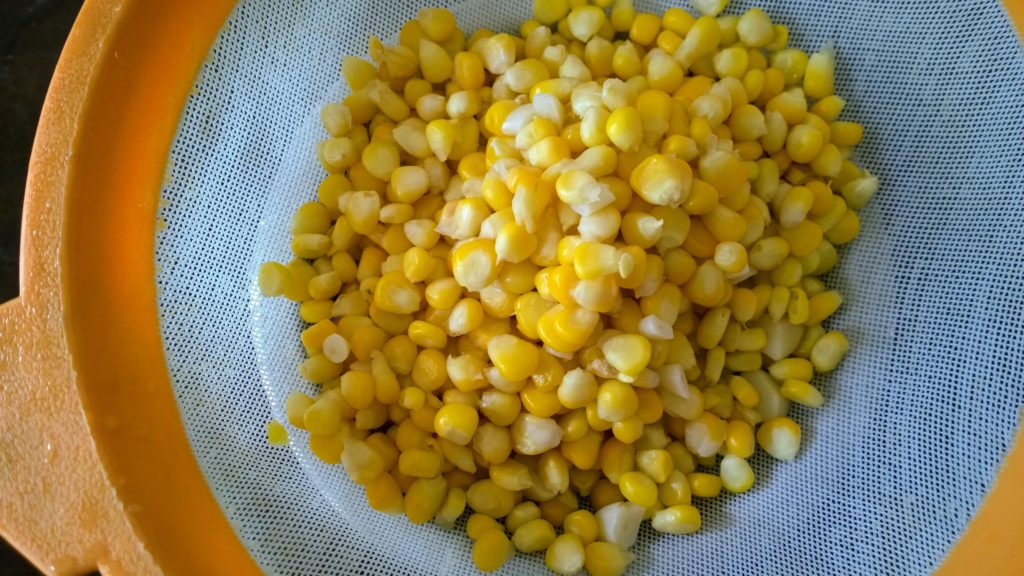 Corn kernels in a strainer