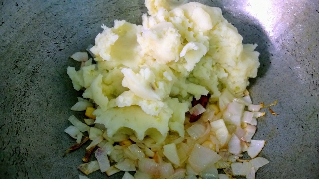 Mashed potato in fried onion and garlic