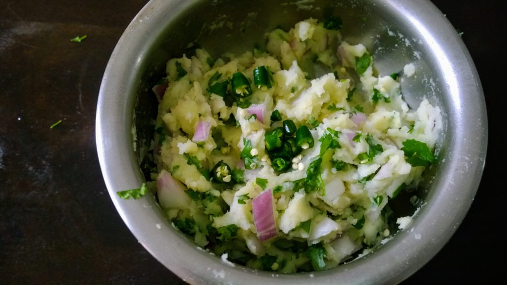 Mashed potato with raw onion, coriander leaves and green chilli