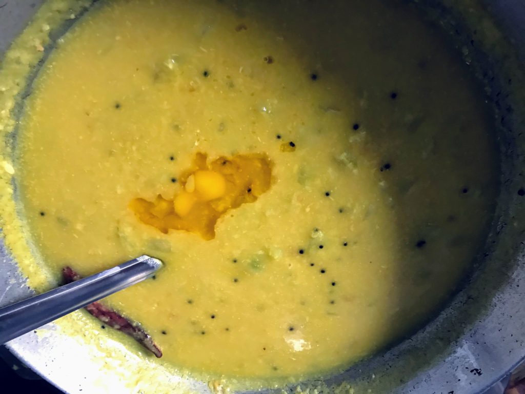 Adding ghee on dal