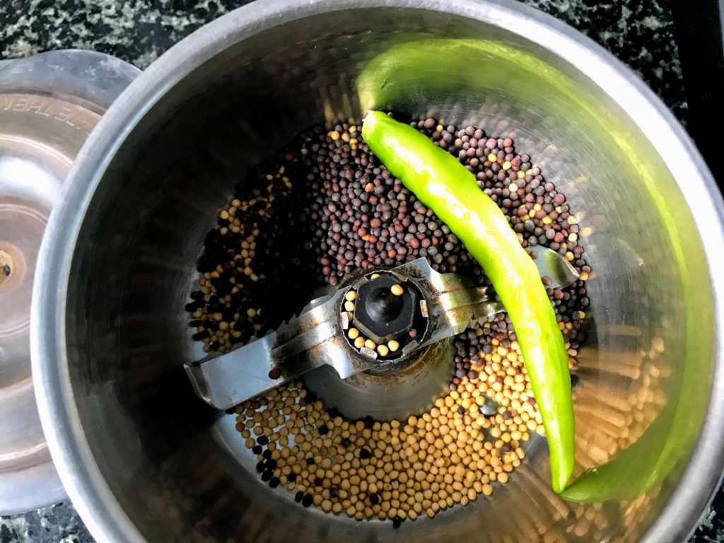 Grinding mustard seeds with green chilli