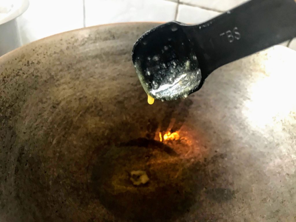 Adding ghee into a pan