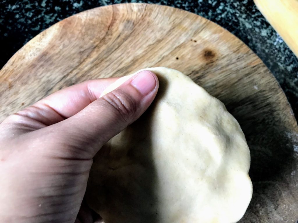 Flattening dough with hand