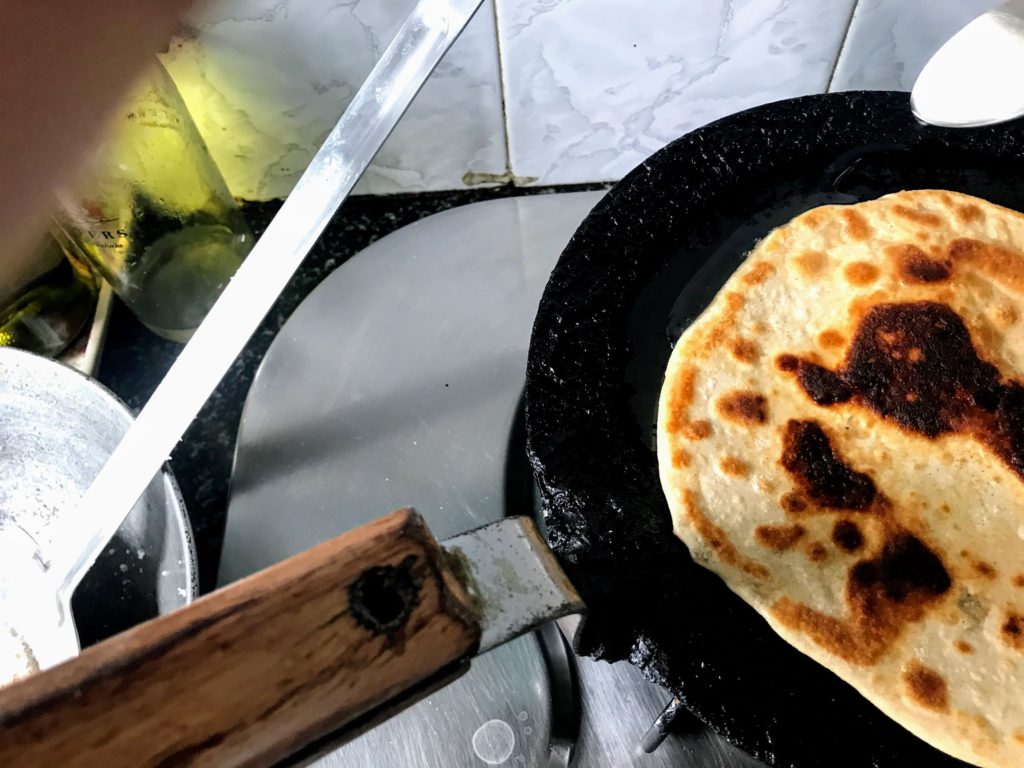 Adding oil on the other side of paratha