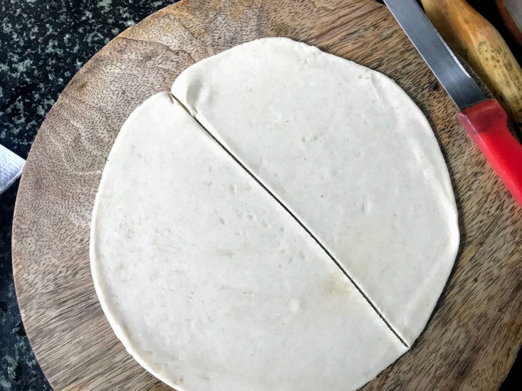 Flattened dough cut into half