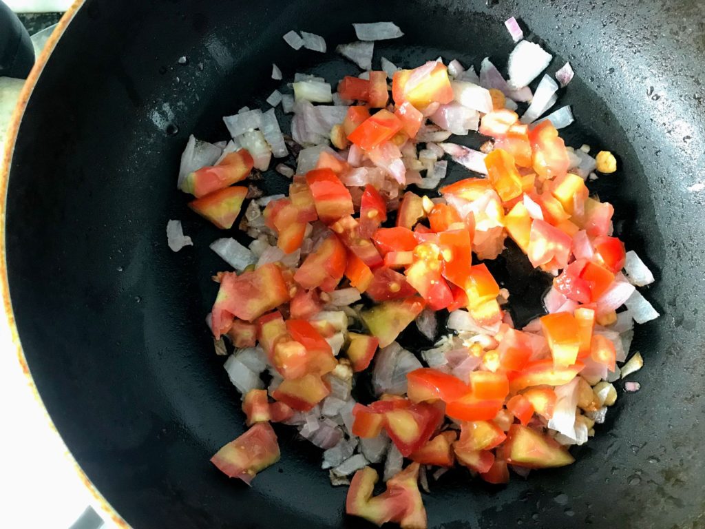 Frying tomato with onion