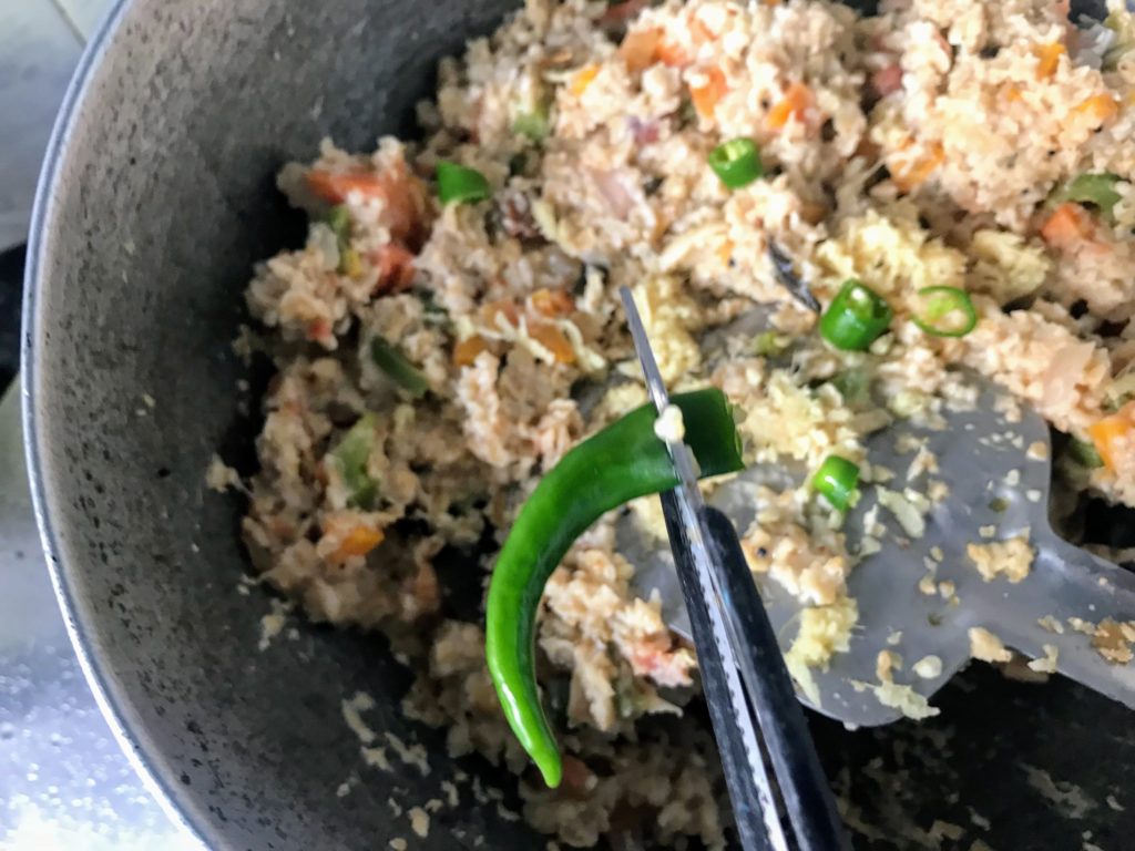Adding green chillies into Oats Upma
