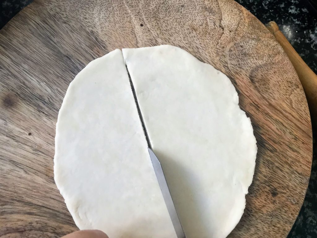 Cutting flattened dough disc from centre