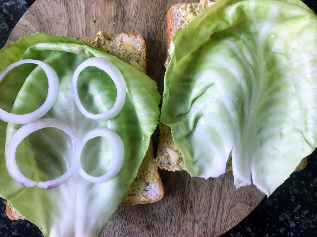 Cabbage leaves and onion rings on bread slices