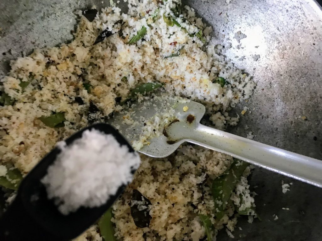Adding salt on grated coconut